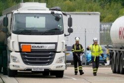 Workers prepare a fuel tanker at Buncefield Oil Depot near Hemel Hempstead, England, Oct. 5, 2021.