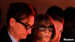 A model is reflected in the glasses of Vogue editor Anna Wintour as she presents a creation from the Creatures of The Wind Autumn/Winter 2013 collection during New York Fashion Week, Feb. 7, 2013.