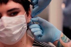 Maddie McFarland, ditindik oleh Jef Saunders, pemilik Gamma Piercing (AP Photo/Carlos Osorio)