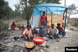 FILE - A man cooks a meal in his makeshift restaurant on the island of Bhasan Char in the Bay of Bengal, Bangladesh, Feb. 14, 2018.