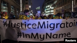 FILE - People take part in a protest in support of a new EU migration policy, a day before an EU leaders' meeting, in Brussels, Dec. 13, 2017.