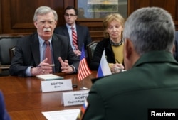 FILE - Russia's Defense Minister Sergei Shoigu, back to camera, meets with U.S. national security adviser John Bolton in Moscow, Oct. 23, 2018.