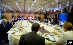 German Chancellor Angela Merkel, right, joins other EU leaders for a breakfast meeting during an EU summit in Brussels, Oct. 20, 2017.