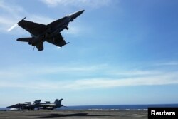 An F18 fighter takes off from the deck of the USS Theodore Roosevelt while transiting the South China Sea, April 10, 2018.