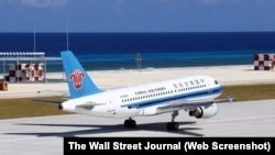 This handout picture from China’s official Xinhua News Agency shows a China Southern Airlines civilian plane landing at a newly-built airstrip on an island at Fiery Cross Reef, in the South China Sea, on Jan. 6, 2016.
