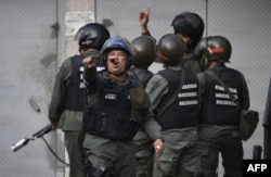 Members of the Bolivarian National Guard throw tear gas againts protesters near Cotiza Bolivarian National Guard headquarter in Caracas, Venezuela, Jan. 21, 2018.