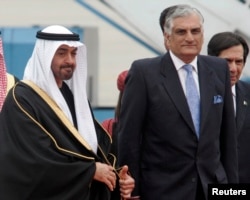 FILE - Zahid Hamid (R) escorts Abu Dhabi's Prince Sheikh Mohammed Bin Zayed al-Nahyan during his arrival at a military base in Rawalpindi near Islamabad, Jan. 18, 2007.