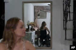 Camila Lima gives an interview from her wheelchair inside her home in Rio de Janeiro, Brazil, Jan. 18, 2019. Lima, who supports tighter gun laws, was hit by a stray bullet in the neck when she was 12 in her Rio neighborhood that left her paralyzed.