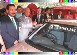 Putra bungsu Presiden Suharto dan Presiden PT Timor Hutomo Mandala Putra, Menteri Perdagangan dan Industri Indonesia Tunky Ariwibowo dan Wakil Ketua Kia Motors Korea Selatan Kim S-A. berpose di depan Timor produksi Korea Selatan. (Foto: AFP/John Macdougal