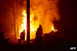 People work to put out a forest fire in Hualqui, 30 kilometers south of Concepcion, Biobio region, Chile, Jan. 27, 2017.