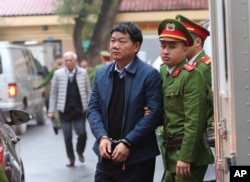 Dinh La Thang, front left, is led into a court room by police in Hanoi, Vietnam, Monday, Jan. 8, 2018.