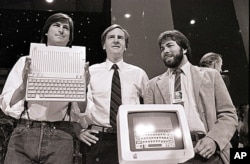 FILE - Steve Jobs, left, John Sculley, center, president and CEO of Apple, and Steve Wozniak, co-founder of Apple, unveil the new Apple II computer in San Francisco on April 4, 1984.