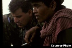 កងទ័ព​សមុទ្រ​នៃ​ចក្រភព​អង់គ្លេស​នៃ​អ៊ុនតាក់ និង​មេដឹកនាំ​ខ្មែរក្រហម​ក្នុង​ស្រុក​កំពុង​ពិភាក្សា​ពី​ដំណើរការ​នៃ​ការបោះឆ្នោត ភាគខាងត្បូង​នៃ​ខេត្តក្រចេះ ខែឧសភា ឆ្នាំ១៩៩៣។ (រូបថតដោយ៖ Tim Page)