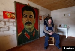 Retired builder Vasili Sidamonidze, 70, poses for a portrait at his home in Gori, Georgia, Dec. 6, 2016.