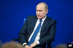 Russian President Vladimir Putin listens to a question while speaking during an election campaign event in Moscow, Jan. 30, 2018.