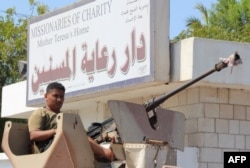 Yemeni pro-government fighters, loyal to exiled Yemeni President Abdu Rabu Mansour Hadi, gather outside an elderly care home in Yemen's main southern city of Aden after it was attacked by gunmen, March 4, 2016.
