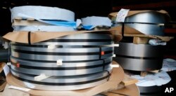 FILE - Rolls of steel sit in a warehouse at a fabrication company in Chester, Va., July 11, 2018.