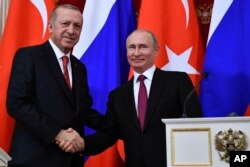 FILE - Russian President Vladimir Putin, right, shakes hands with Turkey's President Recep Tayyip Erdogan after their joint news conference following the talks in the Kremlin in Moscow, Russia, Jan. 23, 2019.