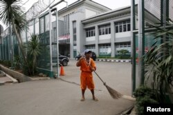 Seorang pekerja menyapu gerbang di penjara Cipinang, 17 Januari 2016