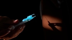 A health worker gives a shot of the Pfizer COVID-19 vaccine at a community health center in Brasilia, Brazil, Jan. 16, 2022.