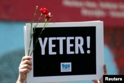 A member of the Journalists Union of Turkey (TGS) holds a placard reading "Enough!" during a demonstration to mark World Press Freedom Day in central Istanbul, Turkey, May 3, 2017.