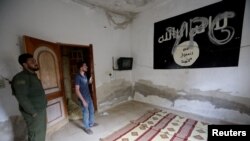 Bendera ISIS di dalam sebuah rumah, di kota perbatasan Tal Abyad, Suriah, 16 Oktober 2019. Badan intelijen Turki MIT berhasil menewaskan seorang yang diduga pemimpin ISIS dalam sebuah operasi.(Foto: REUTERS/Khalil Ashawi)
