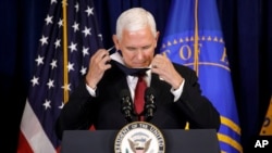 Le vice-président Pence enlève son masque facial alors qu'il arrive au podium pour parler à Rockville, au Maryland, le 30 juin 2020. (AP)