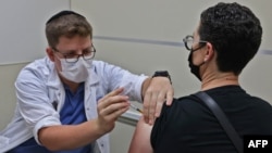 រូបឯកសារ៖ បុគ្គលិក​សុខាភិបាល​អ៊ីស្រាអែល​ម្នាក់ បាន​ចាក់​វ៉ាក់សាំង Pfizer-BioNtech បង្ការ​ជំងឺ​កូវីដ​១៩ ដល់​ពលរដ្ឋ​ម្នាក់​នៅក្នុង​ទីក្រុង​ហ្ស៊េរុយសាឡិម កាលពី​ថ្ងៃទី២០ ខែសីហា ឆ្នាំ២០២១។