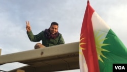 Iraqi Kurdish Peshmerga soldier flashes victory sign as he sits atop his vehicle on Makhmour frontline, where Iraqi forces took their first step in battle for Mosul by trying to capture villages southeast of IS-held city. (S.Behn / VOA) 