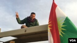 Seorang tentara Kurdi Peshmerga mengacungkan tanda "V" (victory atau kemenangan) ketika pasukan Irak mulai memasuki desa-desa yang dikuasai ISIS di Mosul, Kamis (24/3). 
