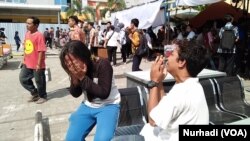 Kakak beradik penyintas gempa bumi di Lombok, menangis di pelataran rumah sakit, 9 Agustus 2018.(Courtesy foto: VOA/Nurhadi)