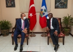 Turkey's Foreign Minister Mevlut Cavusoglu, left, speaks with Claude Joseph, Minister of Foreign Affairs of the Republic of Haiti, during a meeting, in Port-au-Prince, Haiti, Monday, Aug. 17, 2020. (Cem Ozdel/Turkish Foreign Ministry via AP, Pool )