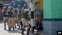 An Indian paramilitary soldier aims his slingshot at Kashmiri protesters near the site of a gunbattle in Srinagar, Indian-controlled Kashmir, May 5, 2018. Fierce clashes erupted when residents in solidarity with the rebels tried to march to the gunbattle site.