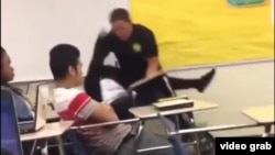 An image from video shows Spring Valley High School (Columbia, S.C., student resource officer Ben Fields, a senior deputy with the Richland County police department, using force to remove a female student from a classroom, Oct. 26, 2015.