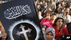 Un homme brandit une Bible lors d’une manifestation dans le sud du Caire, Egypte, 7 mars 2011.