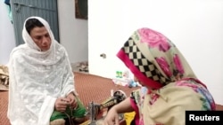 Rani Khan, perempuan transgender yang mengajar Alquran di madrasah (sekolah agama) transgender pertama di Pakistan, tengah mengajar menjahit salah satu siswanya di Islamabad, Pakistan 10 Maret 2021. (REUTERS / Salahuddin)
