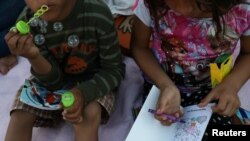 Honduran brother and sister wait on the Mexican side of the Brownsville & Matamoros International Bridge after their asylum-seeking family was denied entry by U.S. Customs and Border Protection officers near Brownsville, Texas, June 26, 2018.