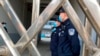 FILE - Security officers stand in formation near a court building in Dandong in northeastern China's Liaoning province, March 19, 2021. 
