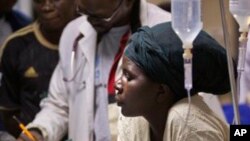 A woman believed to be a relative cradles the head of a young patient injured in a grenade attack at a downtown bus station, at Kenyatta Hospital in Nairobi, Kenya Saturday, March 10, 2012.