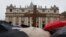 Pilgrims hold a cross in front of St. Peter's Basilica while cardinals meet in the Sistine Chapel to elect a new pope, at the Vatican, March 13, 2013. 