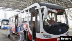 22일 북한 보건 요원들이 신종 코로나바이러스 방역을 위해 버스에 살균액을 뿌리고 있다.