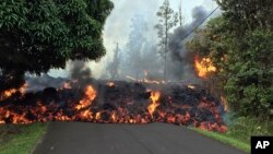 Photo provided by the U.S. Geological Survey shows a lava flow moving across Makamae Street in the Leilani Estates subdivision near Pahoa on the island of Hawaii, May 6, 2018.