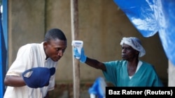 Un agent de santé mesure la température d'un homme entrant dans le centre de traitement Ebola d'ALIMA (The Alliance for International Medical Action) à Beni, en République démocratique du Congo, le 1er avril 2019. (REUTERS/Baz Ratner)