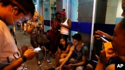 FILE - People surf the Internet at a public Wi-Fi hotspot in downtown Havana, Cuba, March 16, 2016.