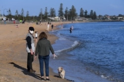 FILE - People enjoy the sunshine, as Victoria state begins easing coronavirus disease (COVID-19) restrictions, at Elwood beach in Melbourne, Australia, Sept. 14, 2020.