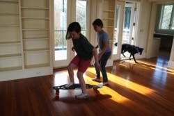 James, 9, and Will, 11, the children of Kate Sullivan Morgan and William Morgan, who relocated so children could attend school in-person, play in the family's new home in Austin, Texas, March 12, 2021.
