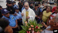 A priest tries to persuade police to let relatives of imprisoned and dead anti-government demonstrators enter the San Miguel Archangel Church in Masaya, Nicaragua, Nov. 14, 2019. The relatives have started a hunger strike.