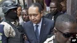Police officers take ex-dictator Jean-Claude Duvalier out of his hotel in Port-au-Prince, Haiti, 18 Jan 2011.