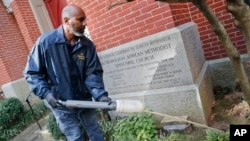 Pest Control Officer Gregory Cornes, from the D.C. Department of Health's Rodent Control Division, uses a duster to pump poison into rat burrows, in downtown Washington, Oct. 17, 2018. (AP Photo/Pablo Martinez Monsivais)