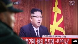Seorang pria menonton pemimpin Korea Utara Kim Jong Ung menyampaikan pidato tahun barunya di TV.